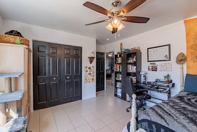 bedroom with ceiling fan, light tile patterned floors, and a closet