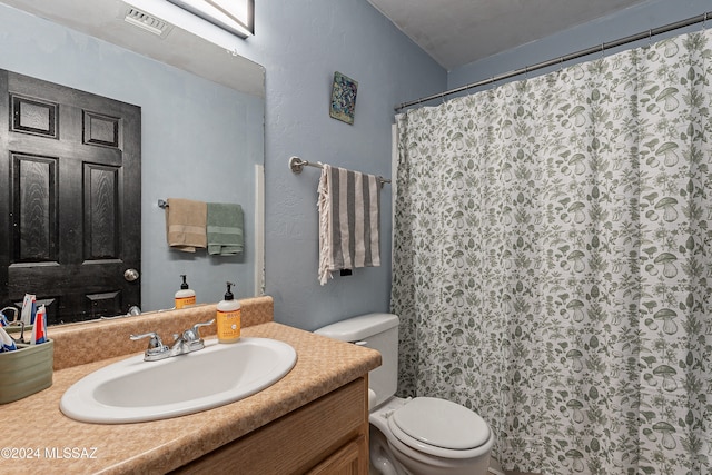 bathroom with vanity, a shower with shower curtain, and toilet