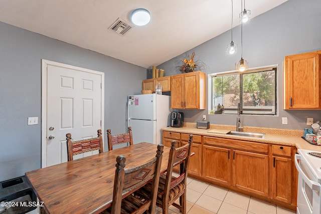 kitchen featuring pendant lighting, lofted ceiling, white appliances, sink, and light tile patterned floors