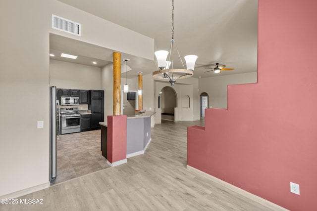 kitchen with ceiling fan, light hardwood / wood-style flooring, stainless steel appliances, and decorative light fixtures