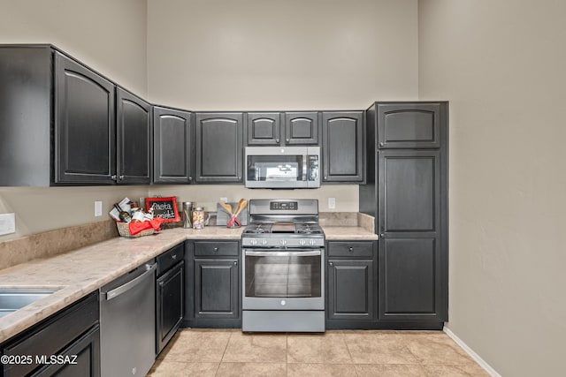 kitchen with light tile patterned floors and stainless steel appliances