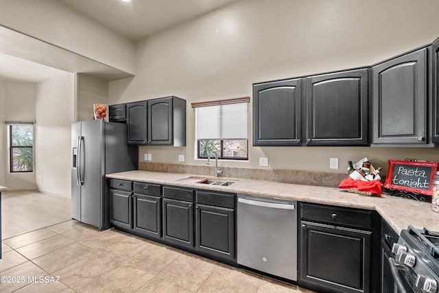 kitchen featuring sink, light tile patterned floors, and stainless steel appliances