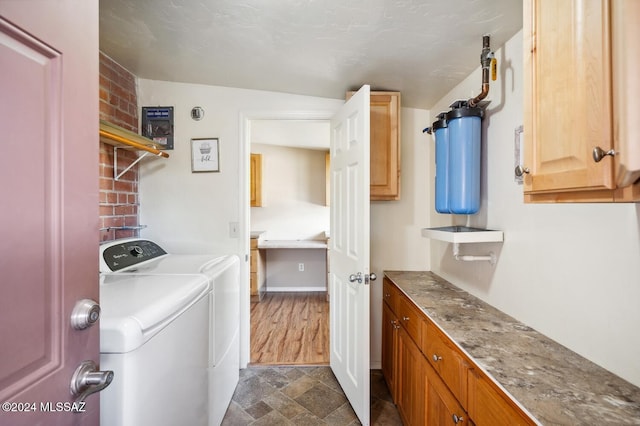 laundry area with washing machine and clothes dryer, cabinets, and dark hardwood / wood-style floors