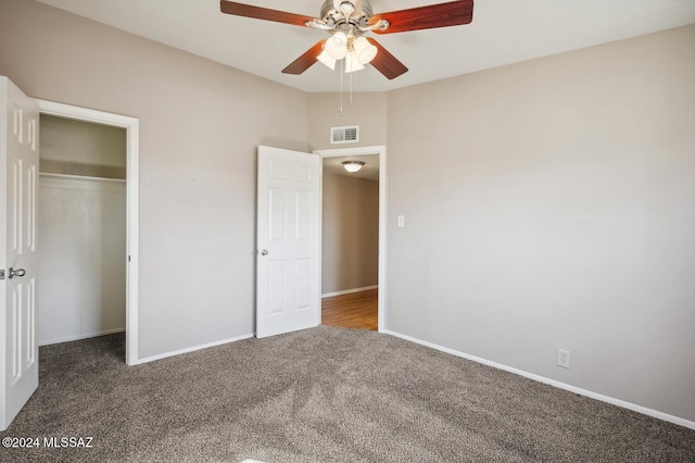 unfurnished bedroom featuring ceiling fan, a closet, and dark colored carpet