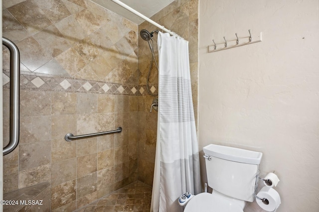 bathroom featuring curtained shower and toilet