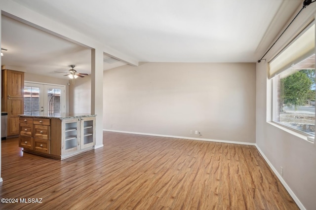 unfurnished living room featuring lofted ceiling with beams, light hardwood / wood-style floors, ceiling fan, and french doors