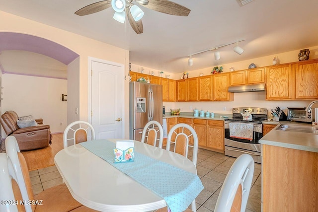 dining area featuring ceiling fan, sink, and light tile patterned flooring