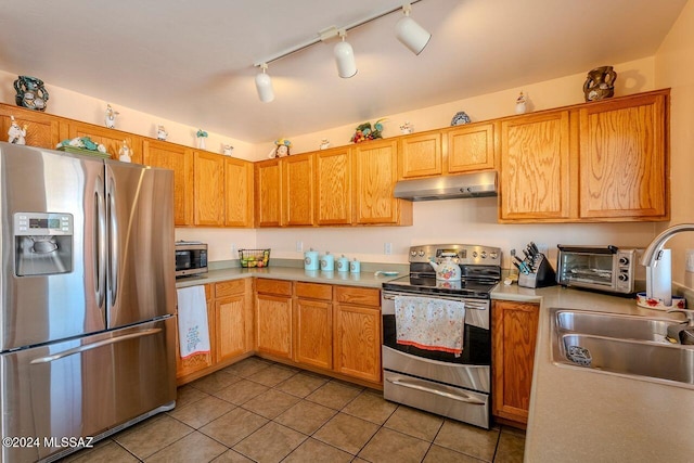 kitchen with rail lighting, sink, light tile patterned flooring, and appliances with stainless steel finishes