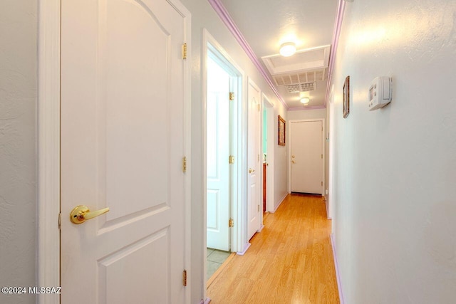 hall with crown molding and light hardwood / wood-style flooring