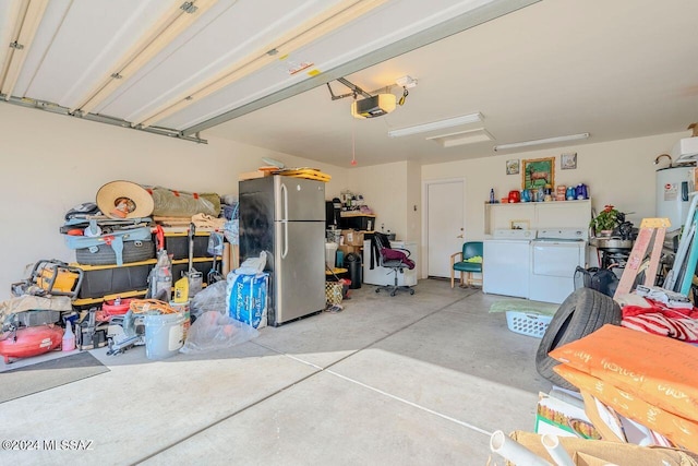 garage with washing machine and dryer, a garage door opener, stainless steel refrigerator, and water heater