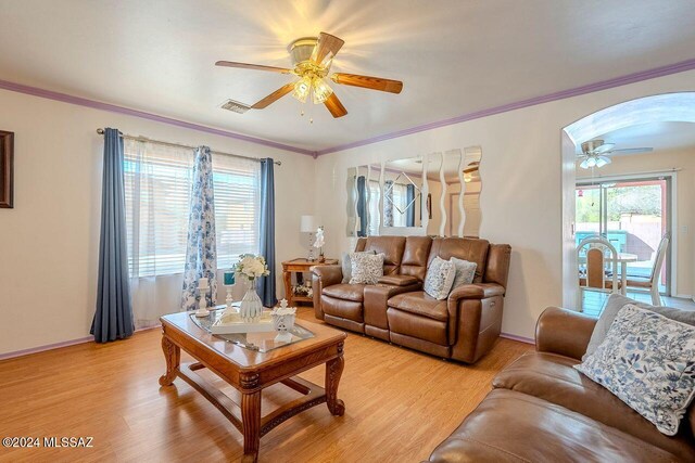 living room featuring a wealth of natural light, crown molding, ceiling fan, and light hardwood / wood-style floors