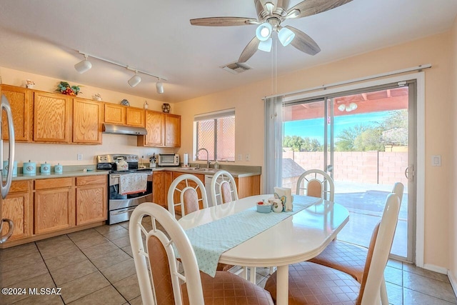 dining area featuring ceiling fan, sink, and light tile patterned floors