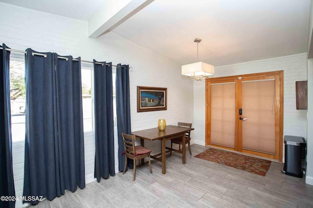 dining room with french doors, brick wall, and an inviting chandelier