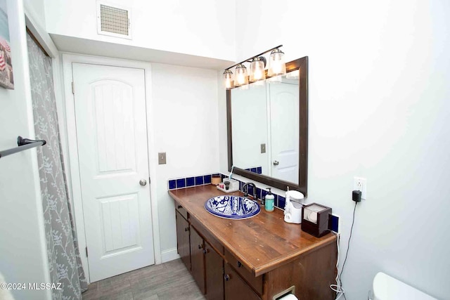 bathroom featuring vanity, wood-type flooring, and toilet