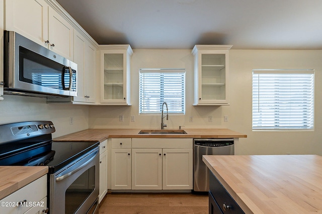 kitchen with white cabinetry, butcher block counters, sink, and appliances with stainless steel finishes