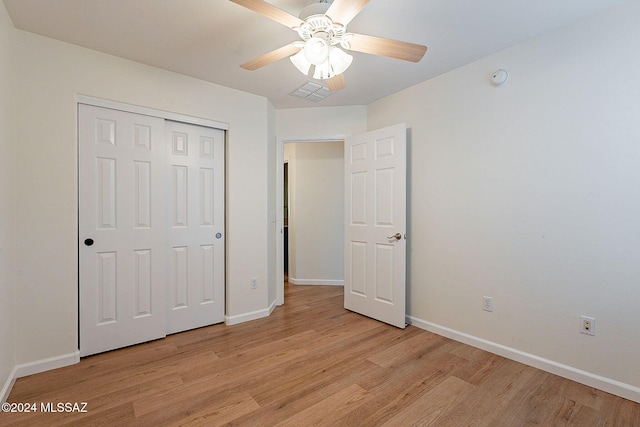 unfurnished bedroom with light hardwood / wood-style flooring, a closet, and ceiling fan