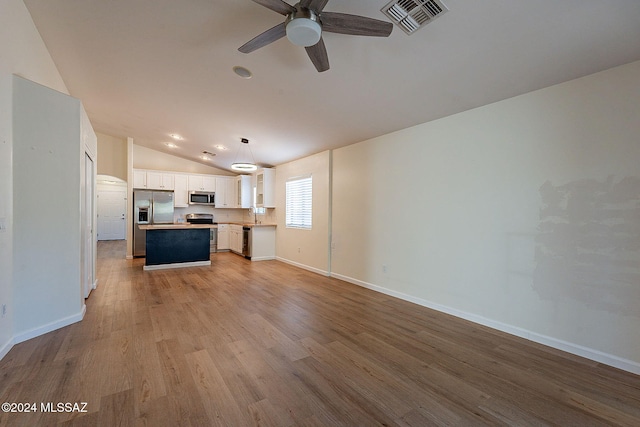 kitchen featuring white cabinetry, hanging light fixtures, appliances with stainless steel finishes, a kitchen island, and light hardwood / wood-style floors