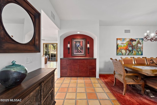 dining room with light tile patterned floors and a chandelier