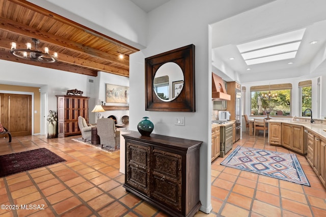 kitchen featuring beam ceiling, wood ceiling, an inviting chandelier, and light tile patterned flooring