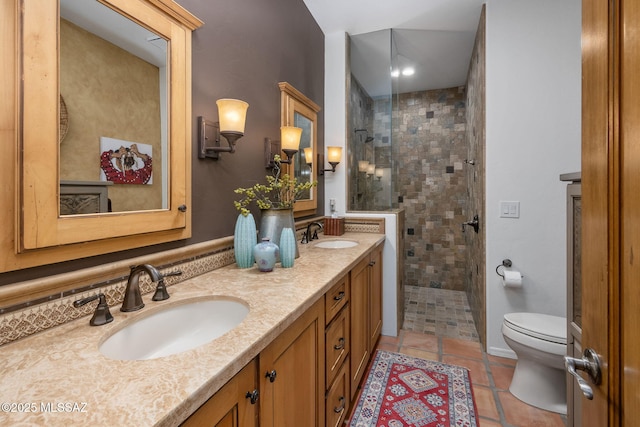 bathroom with tiled shower, vanity, tile patterned floors, and toilet