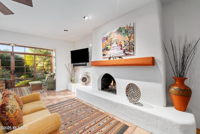 tiled living room featuring ceiling fan, french doors, and a fireplace