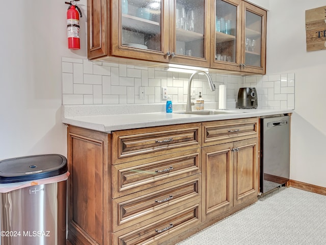 kitchen featuring dishwasher, sink, and tasteful backsplash