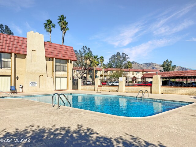 view of swimming pool featuring a mountain view and a patio