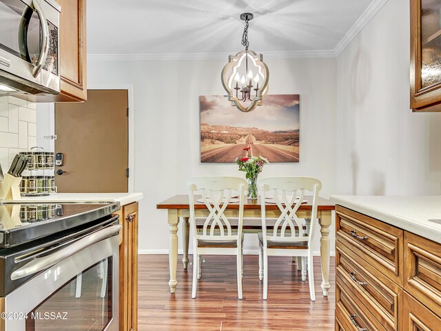 dining room featuring light hardwood / wood-style flooring, an inviting chandelier, and ornamental molding