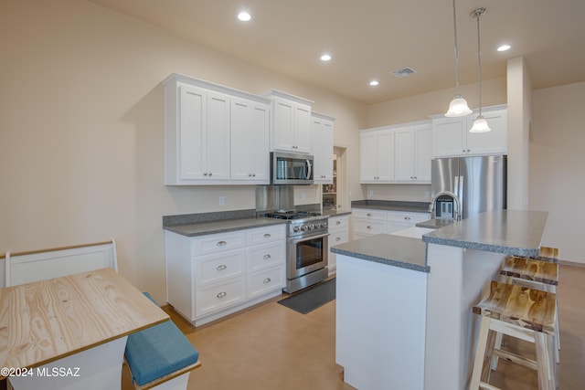 kitchen with pendant lighting, a center island with sink, white cabinetry, and stainless steel appliances