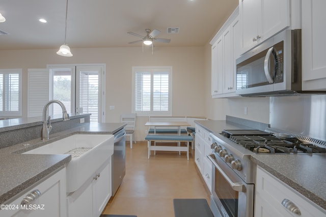 kitchen with decorative light fixtures, stainless steel appliances, white cabinetry, and sink