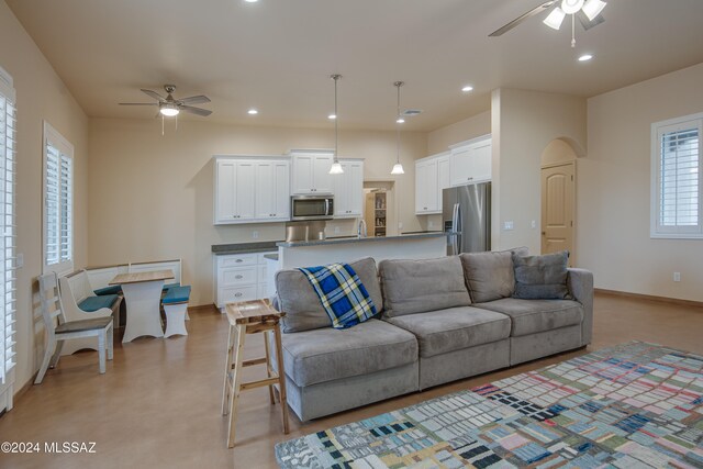 living room featuring ceiling fan and sink