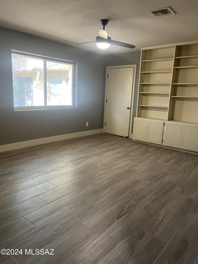 unfurnished bedroom featuring a closet, hardwood / wood-style flooring, and ceiling fan