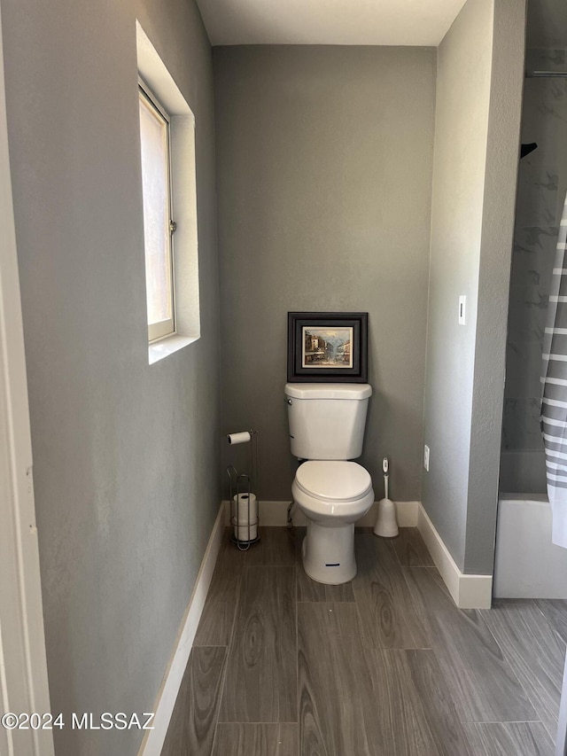 bathroom featuring shower / bathtub combination with curtain and toilet