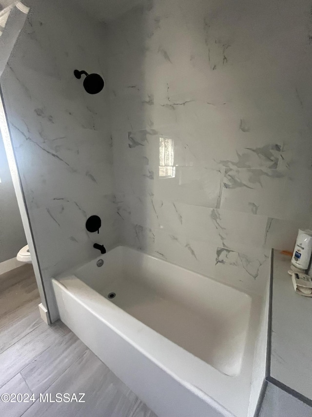 bathroom with tiled shower / bath and toilet