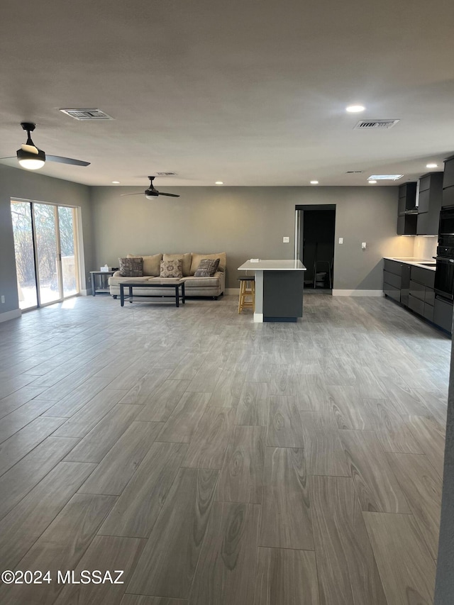 unfurnished living room with ceiling fan