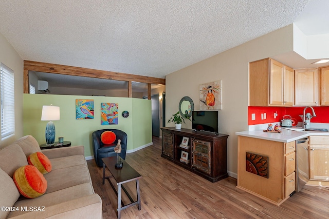 living room featuring a textured ceiling, light hardwood / wood-style flooring, and sink