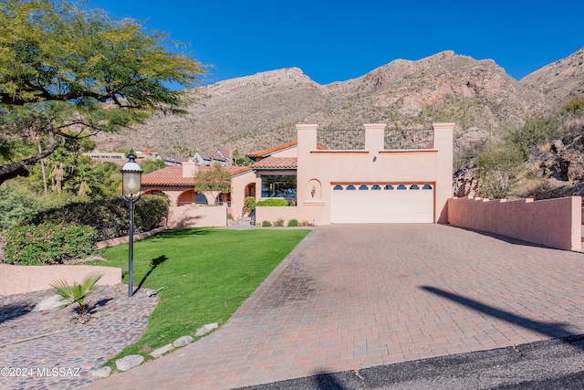 view of front of home featuring a mountain view, a garage, and a front yard