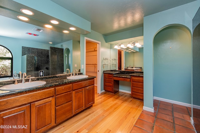 bathroom featuring hardwood / wood-style flooring, vanity, and a shower