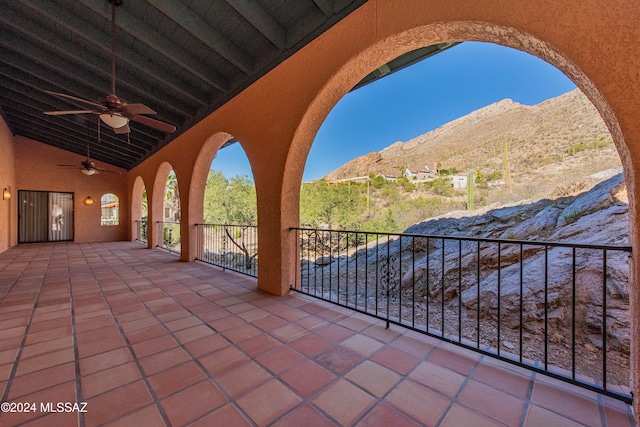 view of patio / terrace with ceiling fan, a balcony, and a mountain view