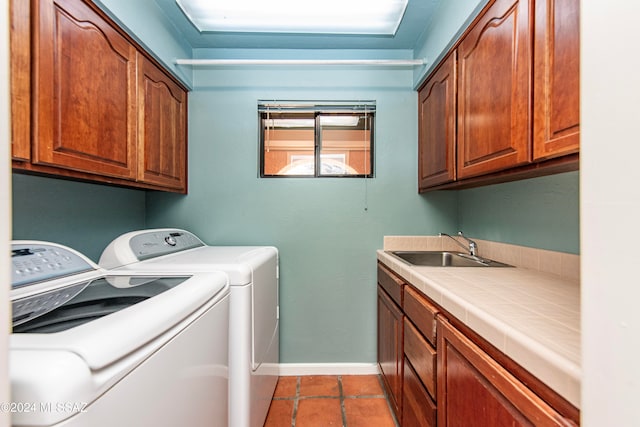 laundry room with washer and clothes dryer, cabinets, and sink