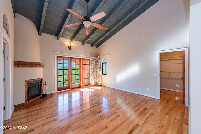 unfurnished living room with ceiling fan, beamed ceiling, high vaulted ceiling, and light hardwood / wood-style flooring