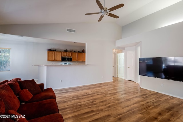 living room featuring hardwood / wood-style flooring, ceiling fan, and high vaulted ceiling