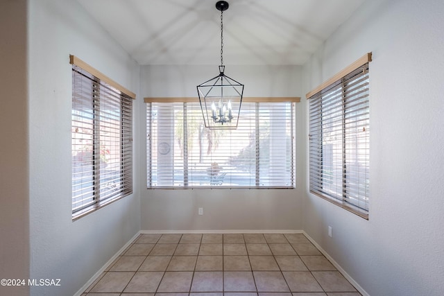 unfurnished dining area featuring tile patterned floors and an inviting chandelier