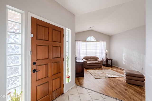 foyer entrance with lofted ceiling and light wood-style floors