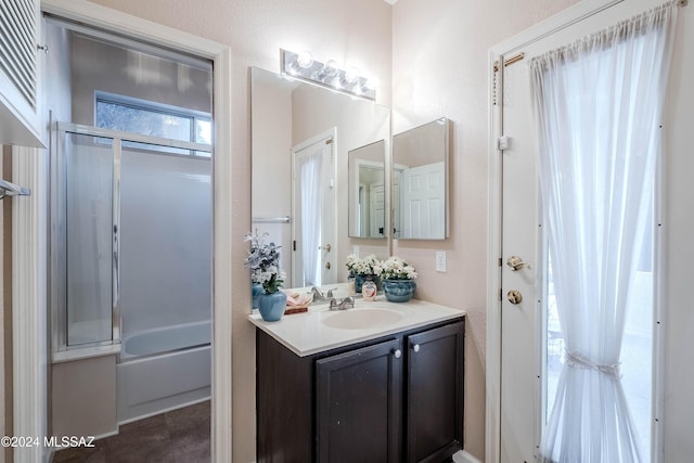 bathroom featuring enclosed tub / shower combo and vanity