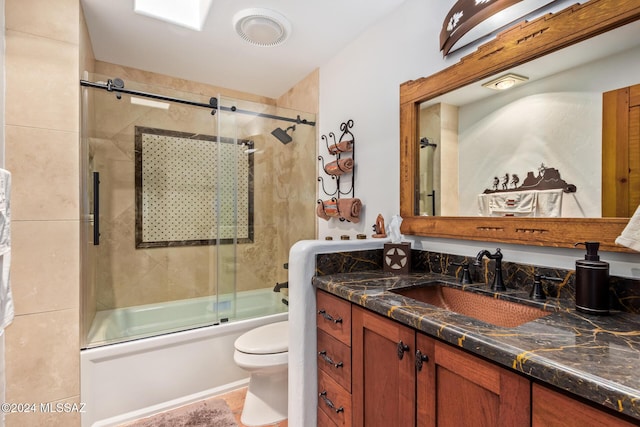 full bathroom featuring bath / shower combo with glass door, toilet, and vanity