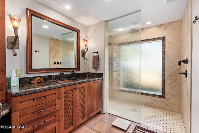 bathroom featuring vanity, tile patterned floors, and tiled shower