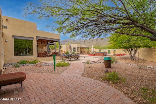 view of patio with a mountain view and a hot tub