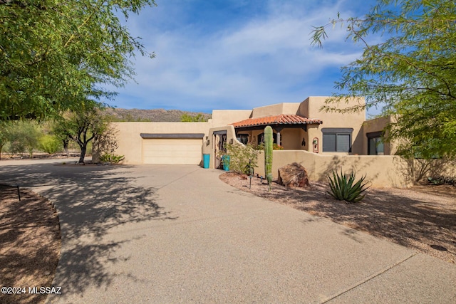 pueblo-style house featuring a garage