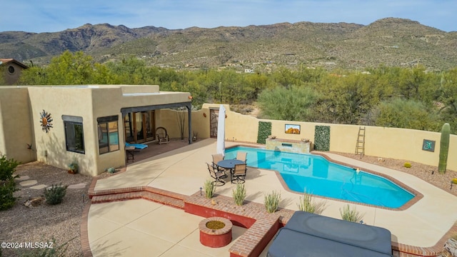 view of swimming pool with a mountain view and a patio